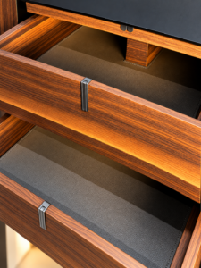 Close-up of wood drawer interior with dividers inside a tall aluminium glass cabinet